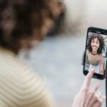 Woman filming herself with a phone on a tripod