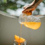 a white plate with a branch of rosemary on it, on a pastel-orange surface